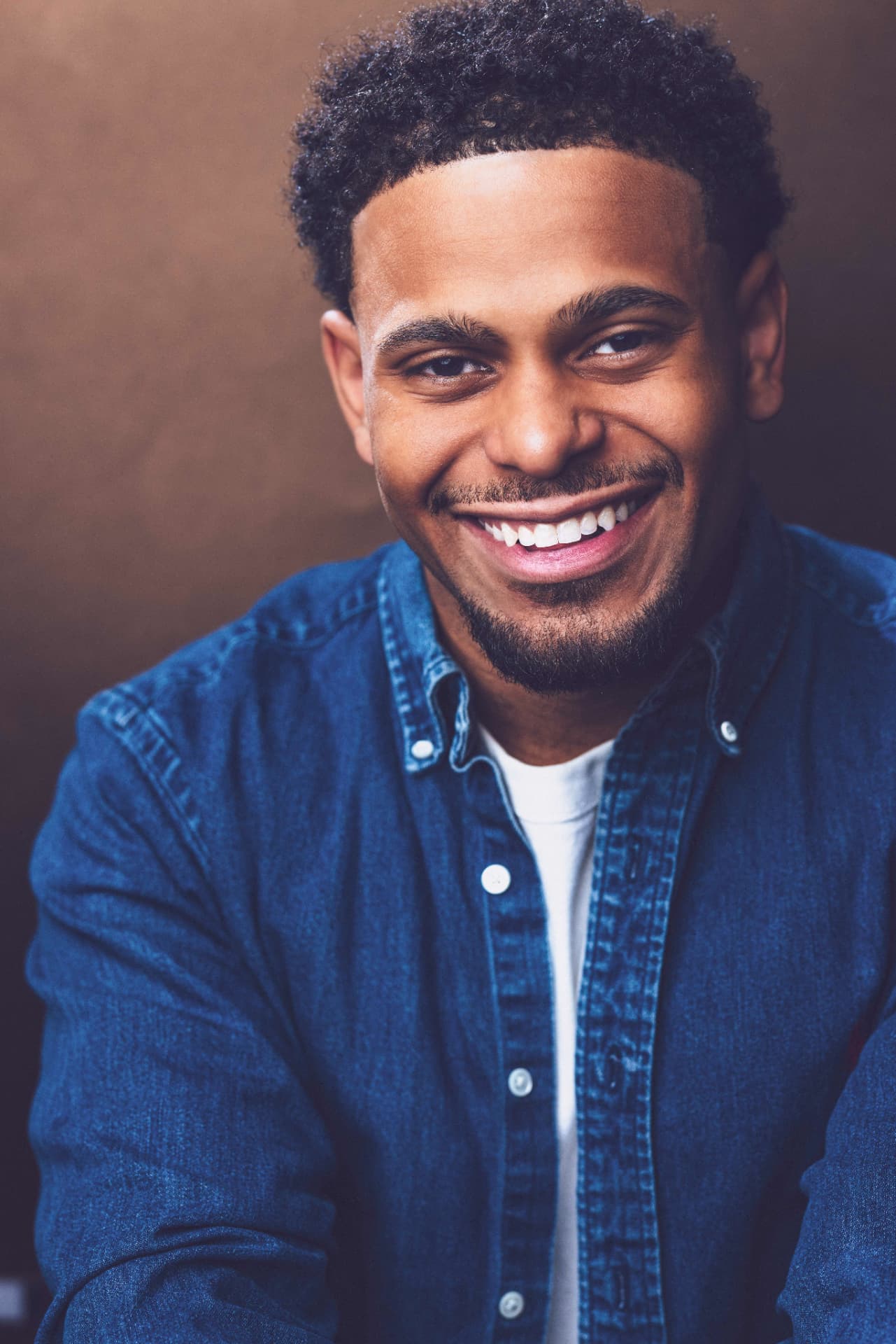 Smiling portrait of Brandon Miles in a denim shirt