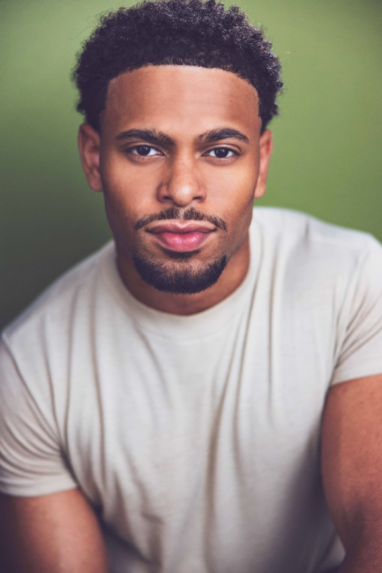 Portrait of Brandon Miles in a light shirt against a green background